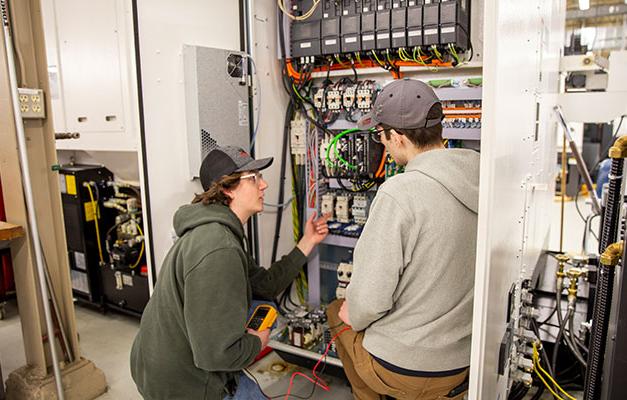 两名学生在安诺卡技术学院从事维修技术员设备的工作.